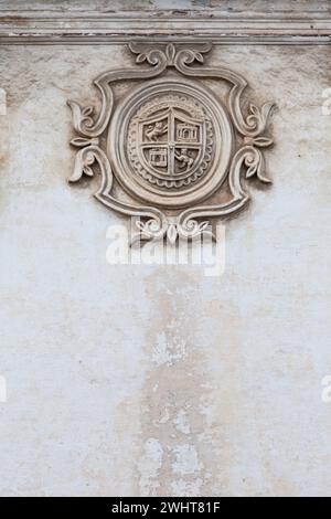 Antigua, Guatemala. Wappen an der Mauer der Universität San Carlos, gegründet 1675. Stockfoto