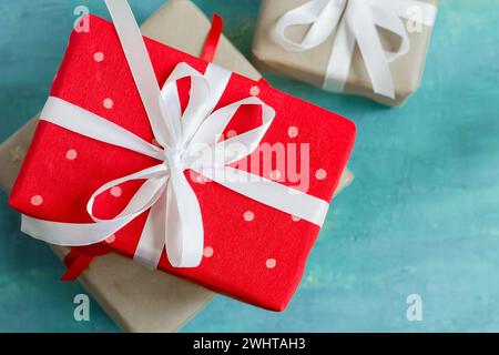 Weihnachtsschachteln mit festlichen Geschenken auf türkisfarbenem Hintergrund Stockfoto