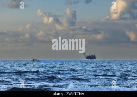 Boot segelt zur Gasplattform vor dem Himmel bei Sonnenuntergang in Israel Stockfoto