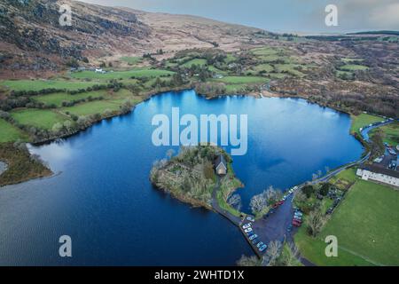 Zeitlose Ruhe in Gougane Barra, County Cork, Irland – wo das Wasser anmutig um eine historische Kapelle fließt und die Essenz der Ruhe einfängt Stockfoto