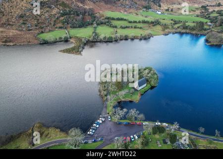 Zeitlose Ruhe in Gougane Barra, County Cork, Irland – wo das Wasser anmutig um eine historische Kapelle fließt und die Essenz der Ruhe einfängt Stockfoto