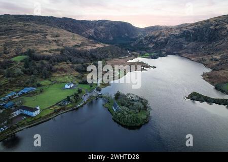 Zeitlose Ruhe in Gougane Barra, County Cork, Irland – wo das Wasser anmutig um eine historische Kapelle fließt und die Essenz der Ruhe einfängt Stockfoto