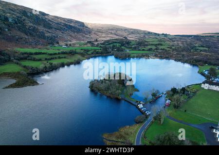 Zeitlose Ruhe in Gougane Barra, County Cork, Irland – wo das Wasser anmutig um eine historische Kapelle fließt und die Essenz der Ruhe einfängt Stockfoto