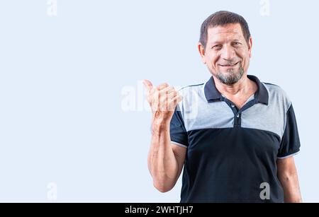 Lächelnder Senior-Mann, der auf ein Banner zur Seite zeigt. Ein älterer Mann, der auf eine Beförderung zeigt Stockfoto