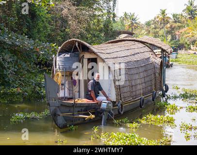 Eine traditionelle Hausboot-Bootstour entlang der Kanäle in der Nähe von Kumarakom bietet einen Einblick in die einzigartige Art, das ruhige Kerala zu erkunden Stockfoto