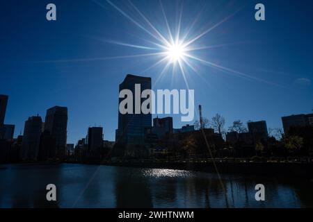 Tokio, Japan. Januar 2024. Der Wasserkanal in den vorderen Gärten des Kaiserpalastes mit den modernen Wolkenkratzern des Stadtzentrums im Hintergrund Stockfoto