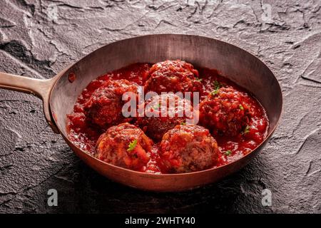 Fleischbällchen. Rindfleischbällchen in einer Pfanne, mit Petersilie und Tomatensauce Stockfoto