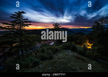 Romantischer Sonnenuntergang in einem kleinen Dorf auf dem Land in slowenischer Wildnis. So ein ruhiger und friedlicher Moment, wenn die Sonne über dem Horizont untergeht. Stockfoto