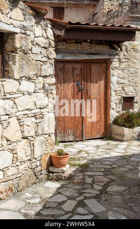 Steiniger Fußweg, der ein traditionelles Dorf durchquert. Steinerne Häuser mit Holztüren. Alte Architektur. Stockfoto