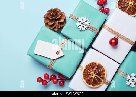 Geschenkkartons in Papier verpackt, mit Kugeln und Garn verziert. Umweltfreundliche Geschenkidee Für Weihnachtsgeschenke Stockfoto