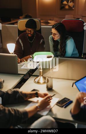 Ein multirassisches Team von Mitarbeitern arbeitet in einem gut beleuchteten Büro zusammen, sucht Brainstorming und findet innovative Lösungen für ihr Startup-Unternehmen. Stockfoto