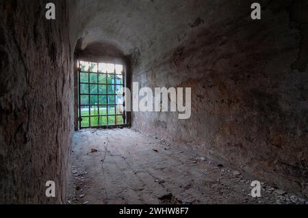 Detail eines kleinen Fensters mit eisernem Gitter in einer antiken Struktur Stockfoto