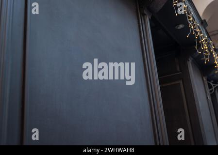 Schwarzes Holzbrett mit freiem Platz für Logo- oder Textwerbung am Eingang zu einem Geschäft, Café oder Restaurant Stockfoto