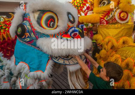 Ein junger westlicher Junge spendet Geld während eines Löwentanzes in einer Skybar zum chinesischen Neujahrsfest, „Jahr des Drachen“. Phnom Penh, Kambodscha. © Kraig Lieb Stockfoto