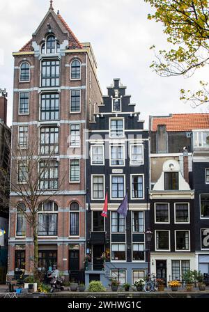 Amsterdam, Niederlande, 20. November 2022. Blick auf traditionelle Gebäude in Amsterdam im Herbst mit Fahrrädern und Bäumen. Stockfoto