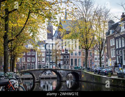 Amsterdam, Niederlande, 20. November 2022. Ruhiger Morgen von Amsterdam im Herbst mit Kanal, Brücke, Gebäuden, Fahrrädern und Bäumen. Stockfoto