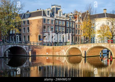 Amsterdam, Niederlande, 20. November 2022. Ruhiger Morgen von Amsterdam im Herbst mit Kanal, Brücke, Gebäuden, Fahrrädern und Bäumen. Stockfoto