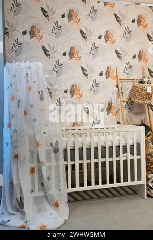 Aufnahme eines Bettes in einem modernen Babyzimmer. Ein Kinderzimmer mit Kinderbett für ein Kind. Stockfoto