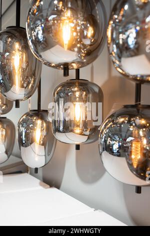 Vintage-Wolfram-Glühfaden mehrere Lampen unterschiedlicher Größe und Stil, die von der Decke hängen. Lampe. Energie- und Designkonzept. Stockfoto