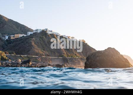 Flacher Blick auf die Stadt Almaciga auf Teneriffa. Wunderschöne Küstenstadt vom Meer aus gesehen bei Sonnenuntergang. Hochwertige Fotos Stockfoto