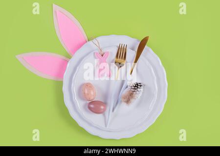 Tischplatz und festliches osterdekor auf pastellgrünem Hintergrund Stockfoto