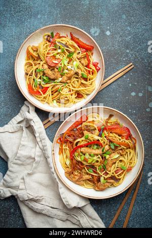 Zwei Schüsseln mit Chow mein oder Lo mein, traditionelle chinesische Rührnudeln mit Fleisch und Gemüse, serviert mit Essstäbchen Top V Stockfoto