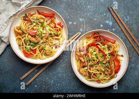 Zwei Schüsseln mit Chow mein oder Lo mein, traditionelle chinesische Rührnudeln mit Fleisch und Gemüse, serviert mit Essstäbchen Top V Stockfoto