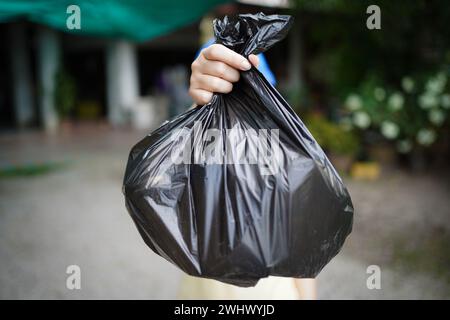 Freiwillige Wohltätigkeitsorganisation womanÂ Hand hält Müllbeutel und Plastikflaschenmüll zum Recycling für die Reinigung im Park Freiwilligendienst Stockfoto