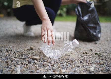 Freiwillige Wohltätigkeitsorganisation womanÂ Hand hält Müllbeutel und Plastikflaschenmüll zum Recycling für die Reinigung im Park Freiwilligendienst Stockfoto