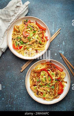 Zwei Schüsseln mit Chow mein oder Lo mein, traditionelle chinesische Rührnudeln mit Fleisch und Gemüse, serviert mit Essstäbchen Top V Stockfoto