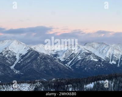 Ein malerischer Sonnenuntergang über Berggipfeln, umgeben von üppigen Bäumen Stockfoto