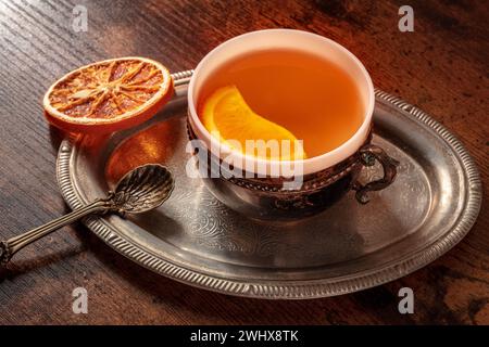 Orangentee mit frischen und getrockneten Orangen auf einem Vintage-Tablett Stockfoto