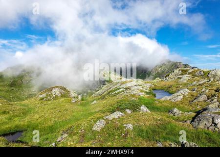 Weiße Wolken über dem See auf der Bergspitze Stockfoto