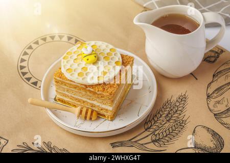 Napoleon Kuchen mit einer Tasse Honig auf Tischdecke, Nahaufnahme Stockfoto