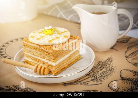 Napoleon Kuchen mit einer Tasse Honig auf Tischdecke, Nahaufnahme Stockfoto