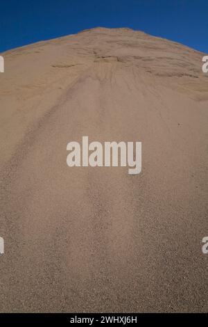 Hügel aus feinem hellbraunem Sand in gewerblicher Sandgrube. Stockfoto