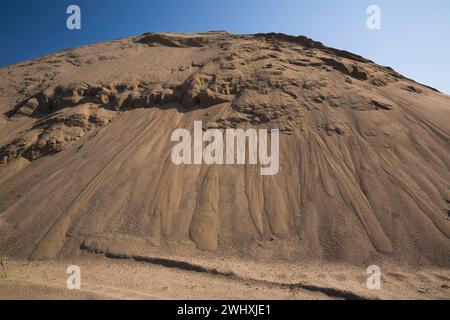 Hügel aus feinem hellbraunem Sand in kommerzieller Sandgrube. Stockfoto