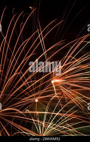 Goldenes, weißes, rotes und grünes Feuerwerk am Nachthimmel. Stockfoto