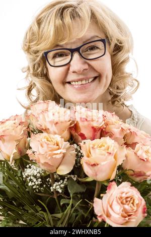 Schöne, blonde Reife Frau mit Rosenstrauß Stockfoto