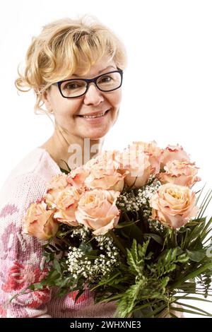 Schöne, blonde Reife Frau mit Rosenstrauß Stockfoto