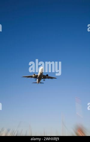 Unterseitenansicht eines gewerblichen Jet-Flugzeugs im Flug mit Bewegungseffekt. Stockfoto