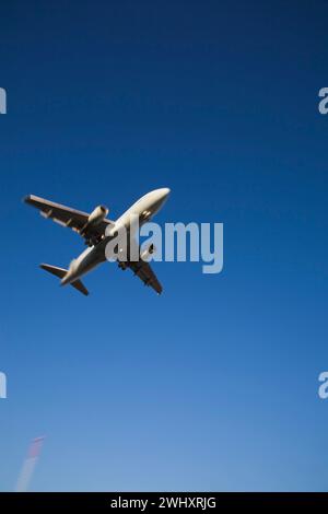 Unterseitenansicht eines gewerblichen Jet-Flugzeugs im Flug mit Bewegungseffekt. Stockfoto