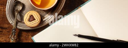 Tagebuch-Mockup mit Tee und Schokoladenkeks, mit Tintenstift, Vintage-Stil Stockfoto