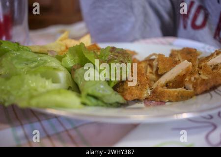 Paniertes Steak mit Pommes frites und Salat zu Hause Stockfoto