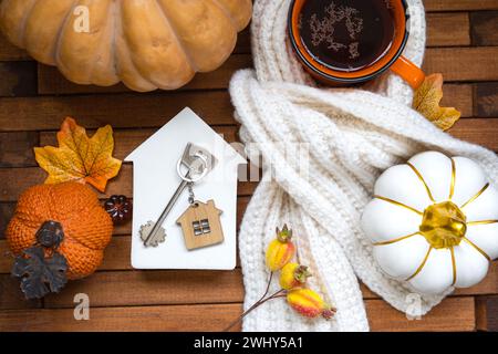 Gemütliches Layout auf einem hölzernen Hintergrund aus Latten mit Kürbissen, Herbstblättern, einem Haus und Schlüsseln - Herbststimmung, Halloween, Gehäuse, re Stockfoto