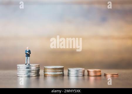 Miniaturmenschen Geschäftsmann, der auf Geld steht Stockfoto