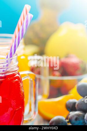 Der frische Ananas- und Erdbeere-Smoothie in Gläsern mit Früchten auf einem blauen rustikalen Holzhintergrund. Frisch gemischtes Sommergetränk, schön, Dura zu trinken Stockfoto