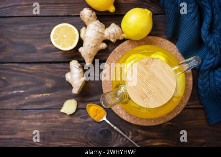 Gesunder Kurkuma Heißgetränk Tee mit Zitrone, Ingwer und Honig auf rustikalem Tisch. Alternative Medizin Konzept, Immunsystem Booster Stockfoto
