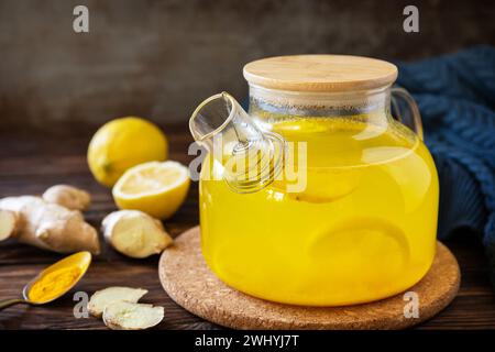 Gesunder Kurkuma Heißgetränk Tee mit Zitrone, Ingwer und Honig auf rustikalem Tisch. Alternative Medizin Konzept, Immunsystem Booster Stockfoto