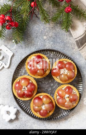 Vorspeisen zu Weihnachten. Tartlets mit Huhn und Trauben auf dem festlichen Tisch. Blick von oben. Stockfoto